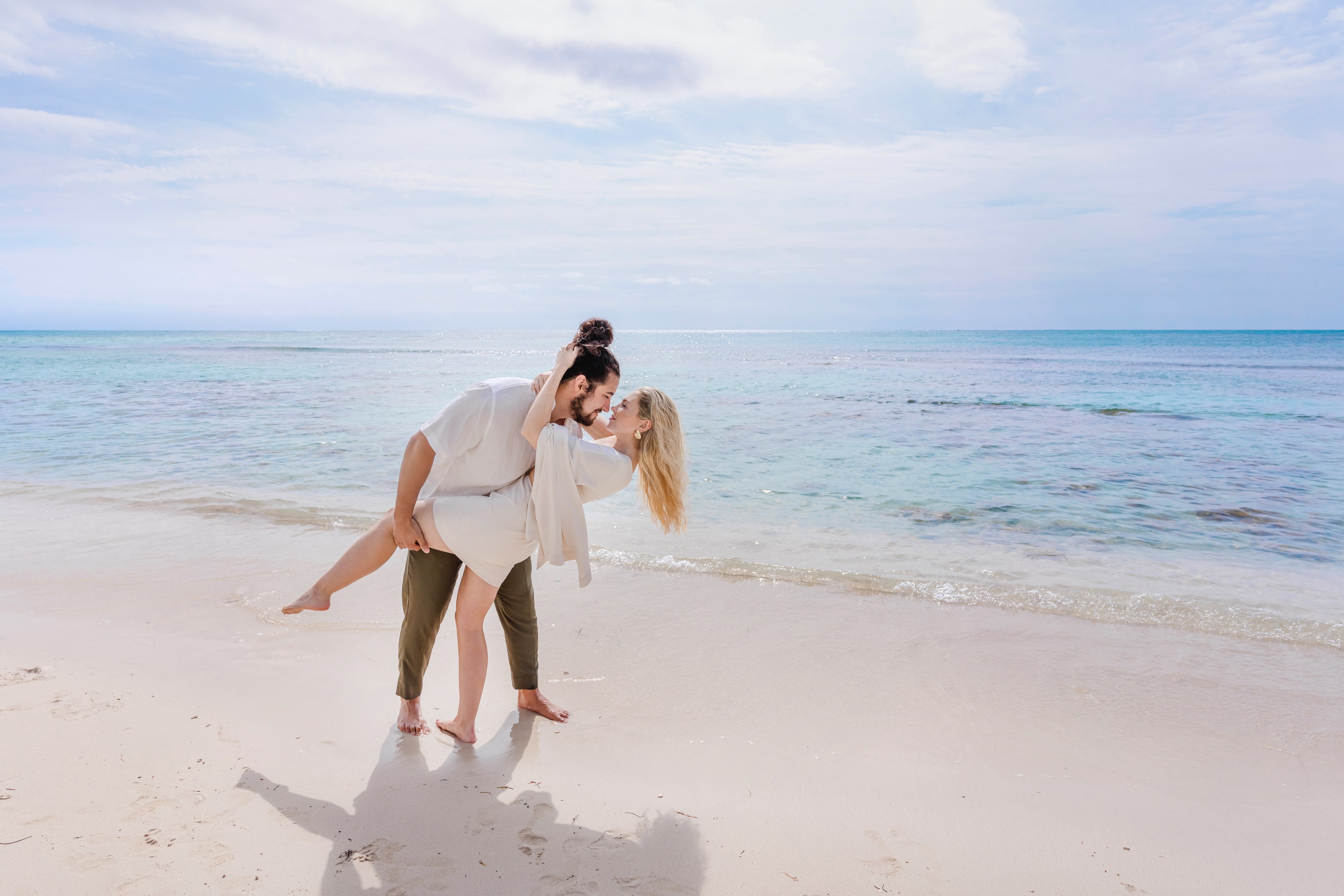 Couple at a Cancún beach walking along the shoreline by IVAE Studios
