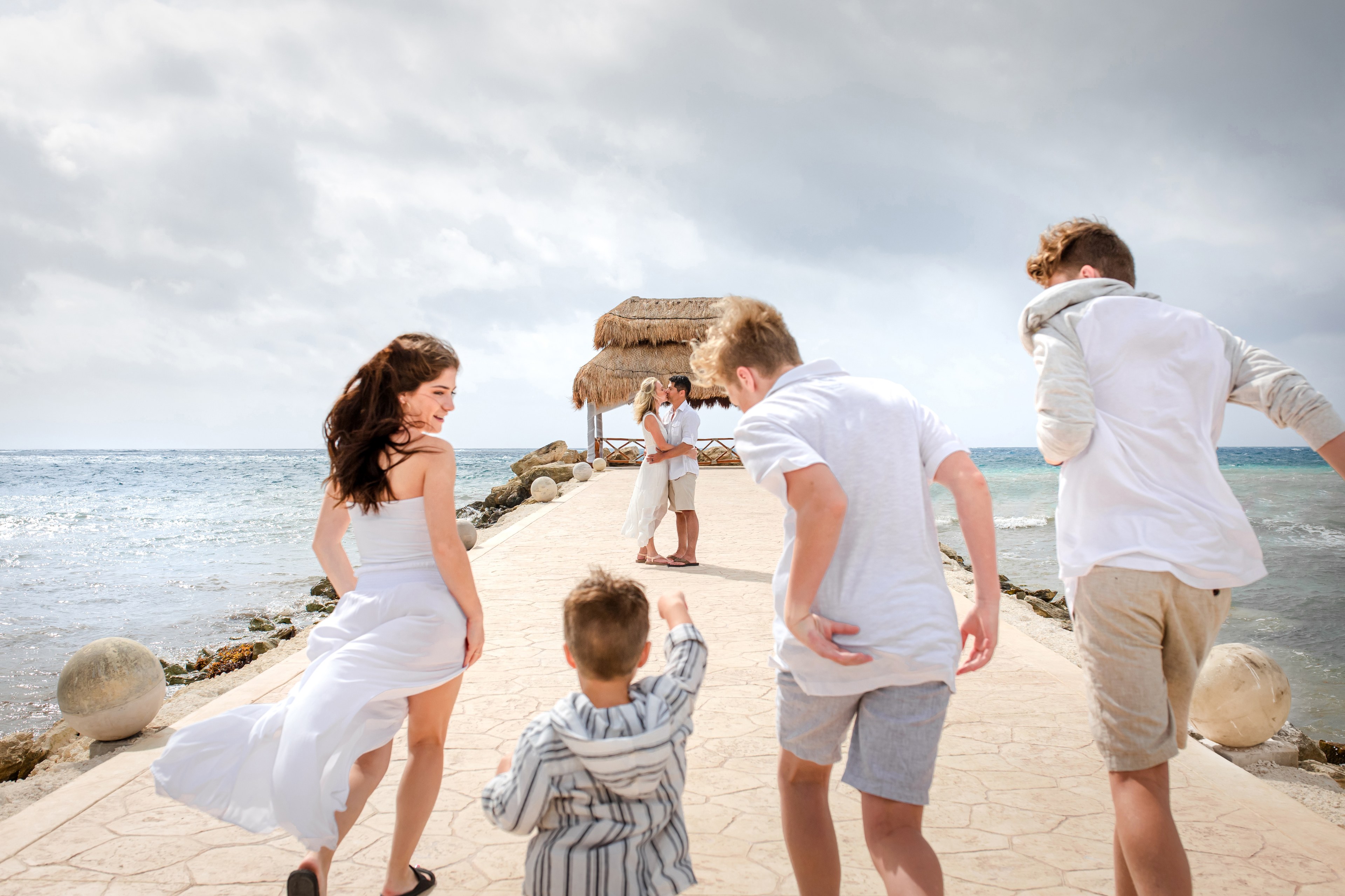 Family at golden hour on Playa Mujeres, photographed by IVAE Studios