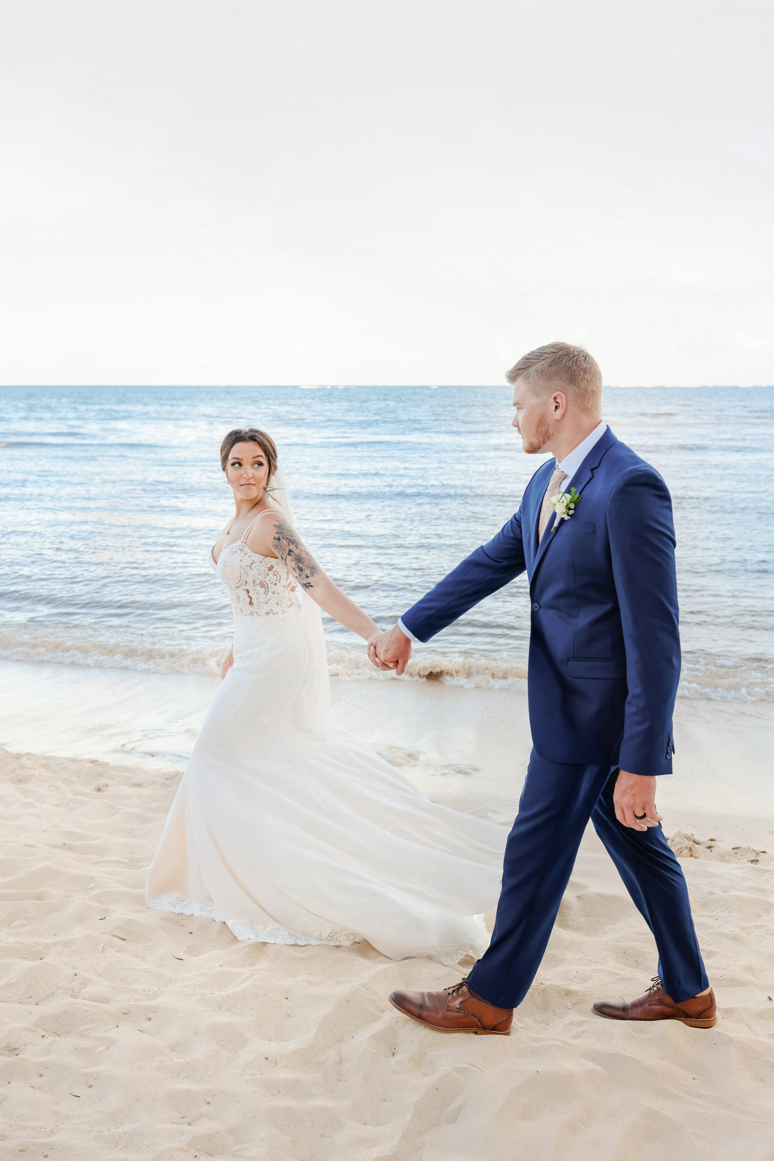 A bride photographed at golden hour on the Cancún Hotel Zone coastline by IVAE Studios